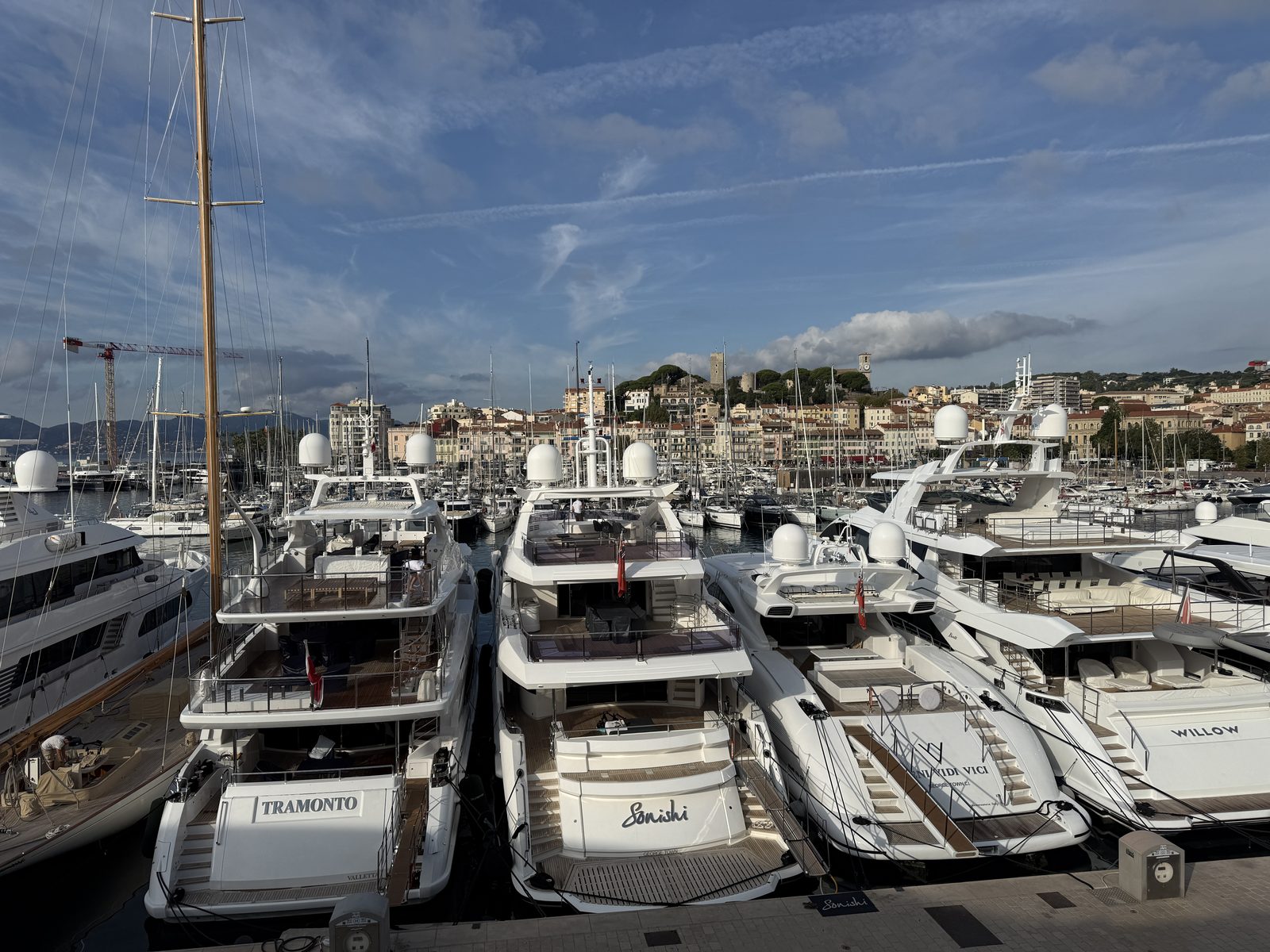 Yachts moored in the Old Port of Cannes with the Le Suquet hill behind