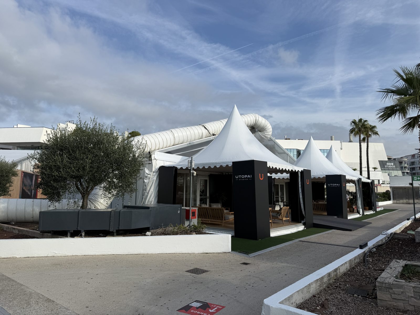 White pavilions outside the Palais des Festivals in Cannes under a blue sky